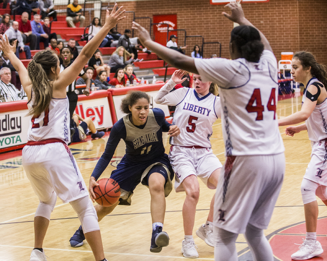 Spring Valley’s Kayla Harris (11) drives past Liberty’s London Pavlica (5) and K ...