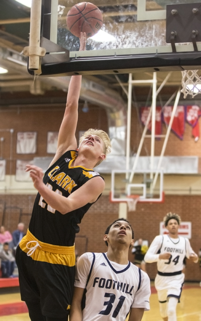 Clark’s Trey Woodbury (22) slices to the basket past Foothill’s Marvin Coleman ...