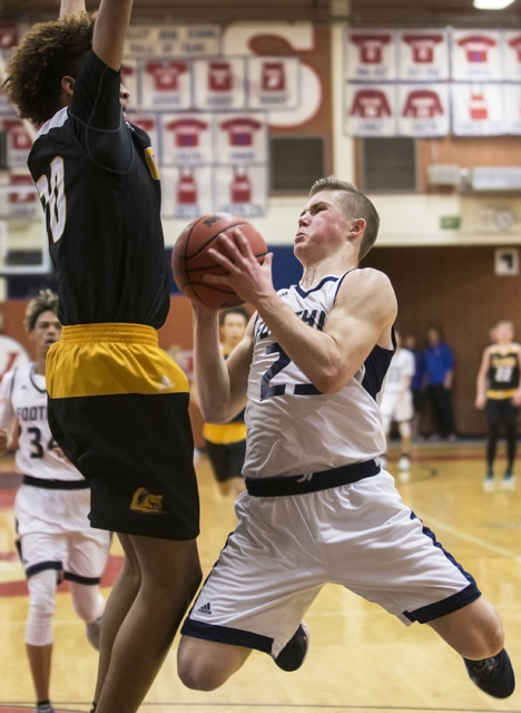 Foothill’s Michael Shaw (23) tries to make an acrobatic basket around Clark’s Ad ...