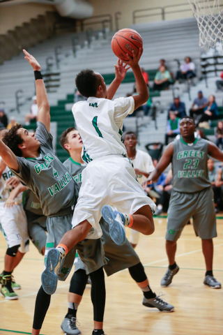 Rancho High School’s David McKeever (1) leaps up and around Green Valley High defender ...