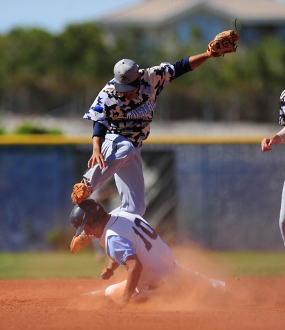 Shadow Ridge shortstop Eric Jordan jumps over Centennial base runner Frank Sessa while turni ...