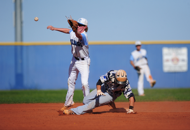 Shadow Ridge baserunner Trevin Reynolds trips over second base after hitting a double while ...