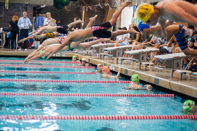 The boys dive in for the start of the 200-yard individual medley race at the Sunset Region m ...