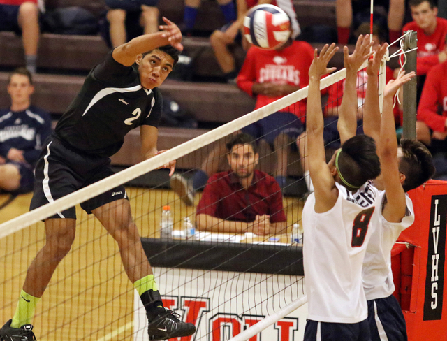 Rancho’s Martin Rodriguez, from left, spikes the ball as Liberty’s Daniel Lusung ...