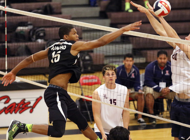 Rancho’s Lamont Taylor, from left, spikes the ball as Liberty’s Ryan Taggart sta ...
