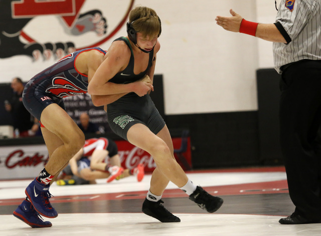 Green Valley’s Tyler Dockery, green singlet, attempts to escape from Liberty’s J ...