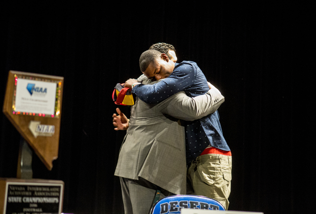 Senior Randal Grimes hugs Desert Pines coach Tico Rodriguez after signing to play college fo ...
