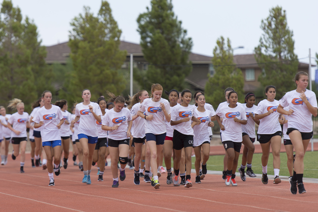 The girls soccer teams run around the track during practice at Bishop Gorman High School in ...