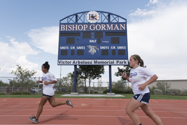 Members of the girls soccer teams run around the track during practice at Bishop Gorman High ...