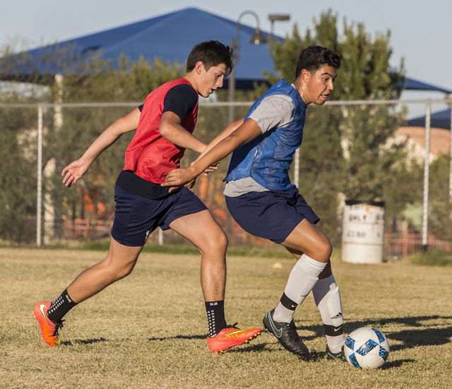 Spring Valley soccer player Jose Lopez, right, dribbles past a defender during practice on ...