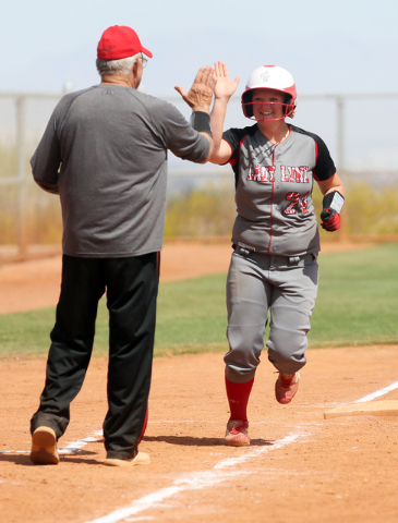 Lincoln County coach Pat Kelley, left, congratulates Aspen Wilkin after she hit a home run a ...