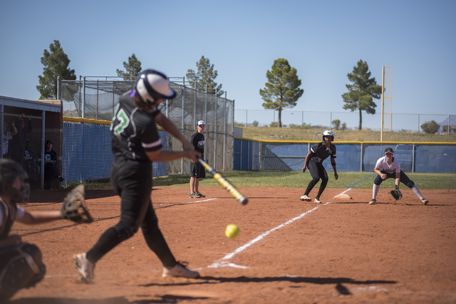 Palo Verde High School’s Kali Tomlinson (17) swings at a pitch as Dejanae Gage (2) tak ...