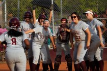 Faith Lutheran’s Cheyenne Kidd (8) is greeted at home plate by her teammates after hit ...