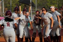 Faith Lutheran’s Cheyenne Kidd (8) is greeted at home plate by her teammates after hit ...