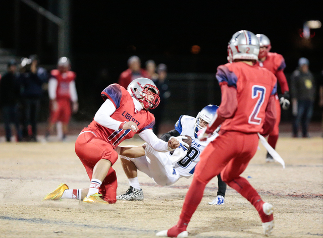 Basic’s Dallon Ellett (88) is knocked back by Liberty’s Preston Pavlica (11) dur ...