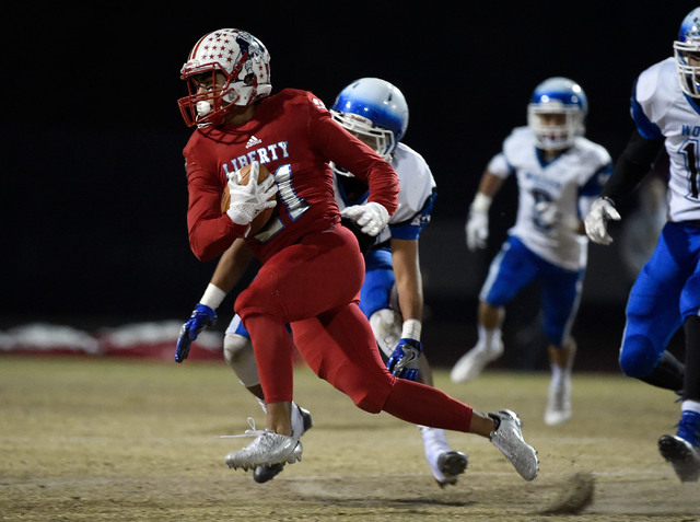 Liberty’s Darion Acohido (21) runs against Basic during a high school football game at ...