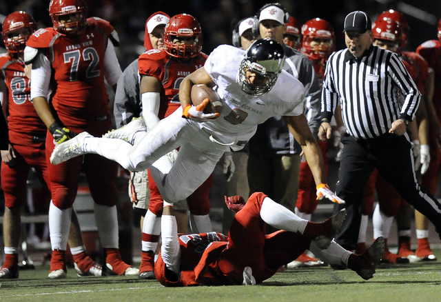 Bishop Gorman tight end Alize Jones (8) is tripped up by Arbor View safety Herman Gray (34) ...