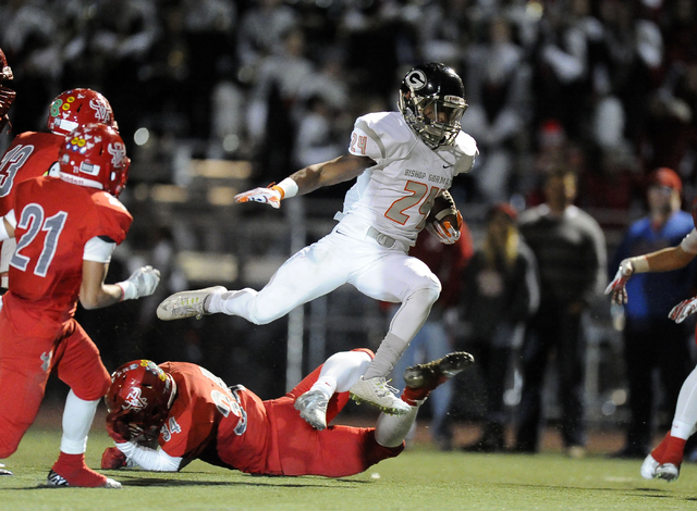 Bishop Gorman halfback Russell Booze (24) gains a first down as Arbor View safety Herman Gra ...