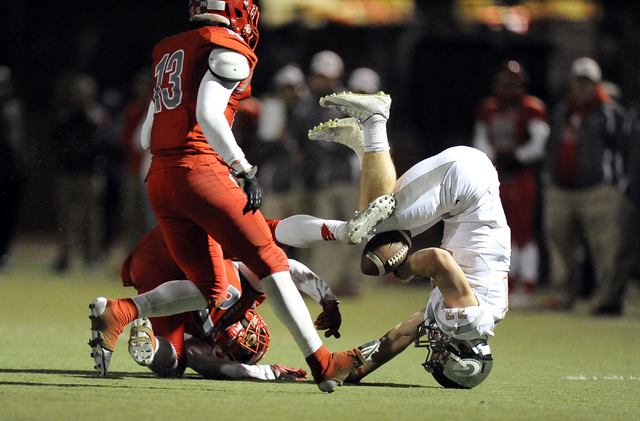 Bishop Gorman running back Jonathan Shumaker, right, loses the ball while being tackled by A ...