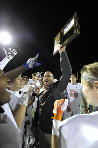 Bishop Gorman head coach Tony Sanchez, center, hoists the Sunset Region championship trophy ...