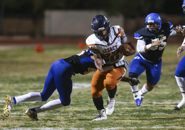 Legacy’s Samuel Turner (22) is tackled by Sierra Vista’s Kevin McCray (46) durin ...
