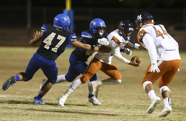 Legacy quarterback Roberto Valenzuela (5) tries to avoid being tackled by Sierra Vista defen ...