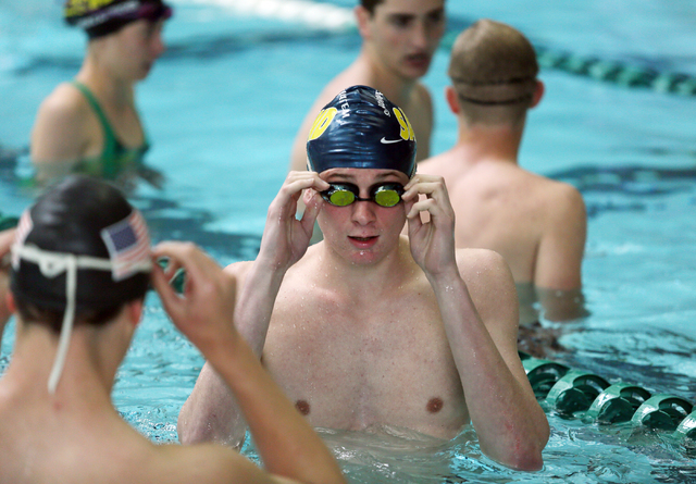 Faith Lutheran senior Bowen Becker, 17, center, puts on his goggles during practice at Pavil ...
