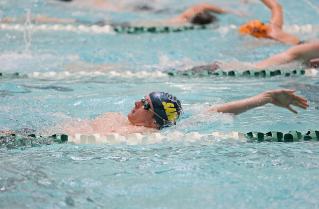 Faith Lutheran senior Bowen Becker, 17, front, swims the backstroke during a warm-up at prac ...