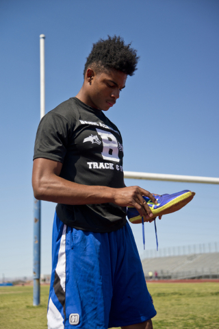 Basic High School high jumper Frank Harris puts on his shoes during track practice at Basic ...