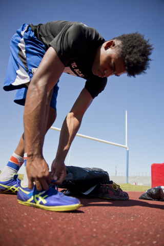 Basic High School high jumper Frank Harris laces his shoes during track practice at Basic Hi ...
