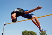 Basic High School high jumper Frank Harris clears the bar while demonstrating his high jump ...