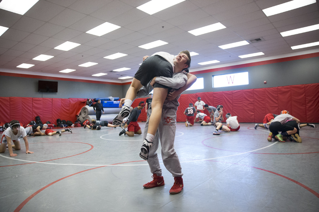 Dawson Downing, right, 17, lifts Ryder Marchello, 17, during a wrestling practice at Arbor V ...