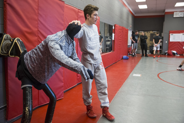 Dawson Downing, 17, watches his teammates wrestle during a practice at Arbor View High Schoo ...