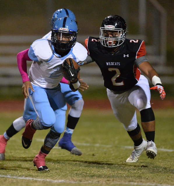 Canyon Springs junior Diamante Burton (2) runs away from Las Vegas linebacker Cruz Littlefie ...