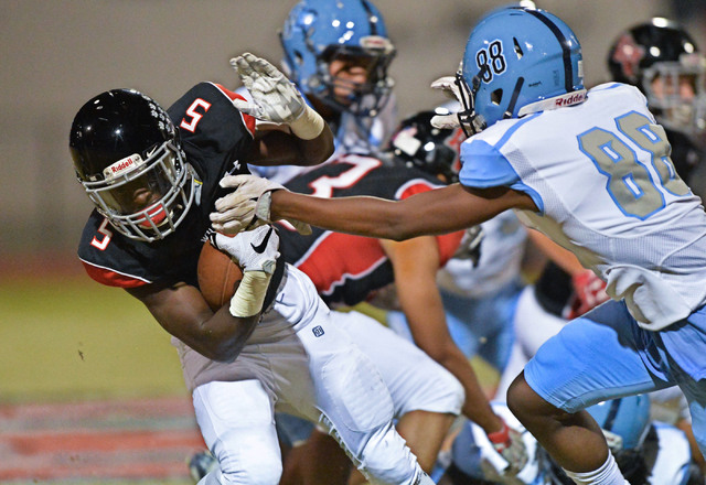 Las Vegas kick returner Eric Williams (5) tries to avoid a tackle during the Las Vegas High ...