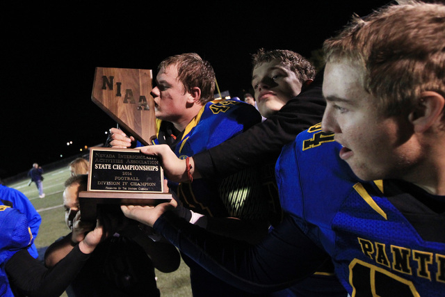 Pahranagat Valley’s Paden Higbee kisses the Division IV state championship trophy whil ...