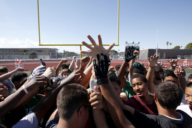 Rancho High School football players huddle during practice on Thursday. The team will play a ...