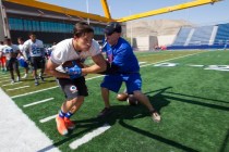Bishop Gorman running back Baggio Ali Walsh, left, (7) takes a football from a coach as he r ...