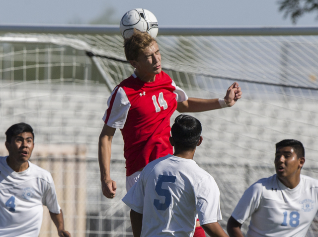 Arbor View junior midfielder Zachary Breaz (14) fights for a header with Canyon Springs defe ...