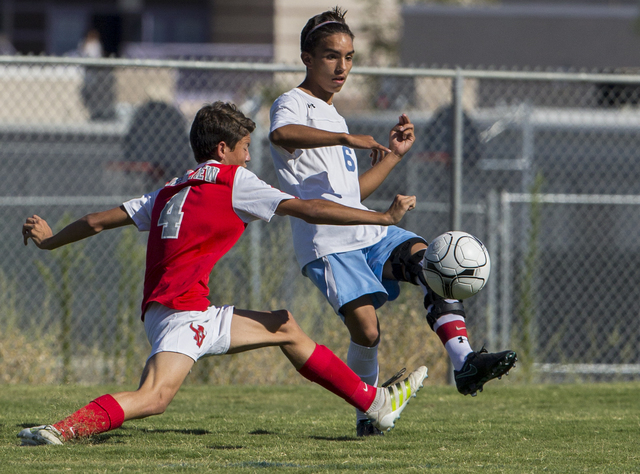 Canyon Springs junior midfielder Edgar Donate (6) makes a pass around Arbor View sophomore d ...