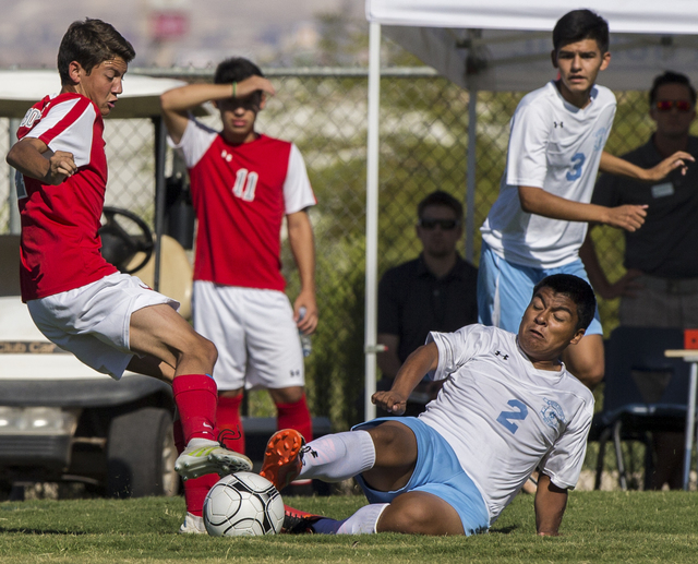 Canyon Springs sophomore midfielder Chris Mata (2) slide tackles Arbor View sophomore defend ...