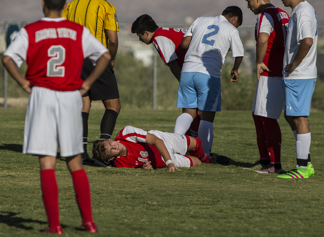 Arbor View junior midfielder Zachary Breaz (14) waits for medical attention after colliding ...