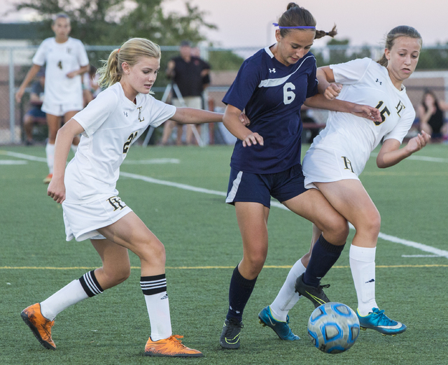 Centennial’s Lauren Levoyer (6) fights for a ball with Faith Lutheran’s Amelia M ...