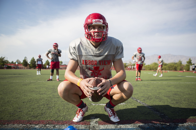 Arbor View High School quarterback Hayden Bollinger prepares to begin a play during football ...
