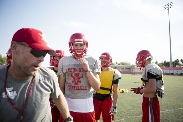 Arbor View High School quarterback Hayden Bollinger, center, breaks for practice at the scho ...