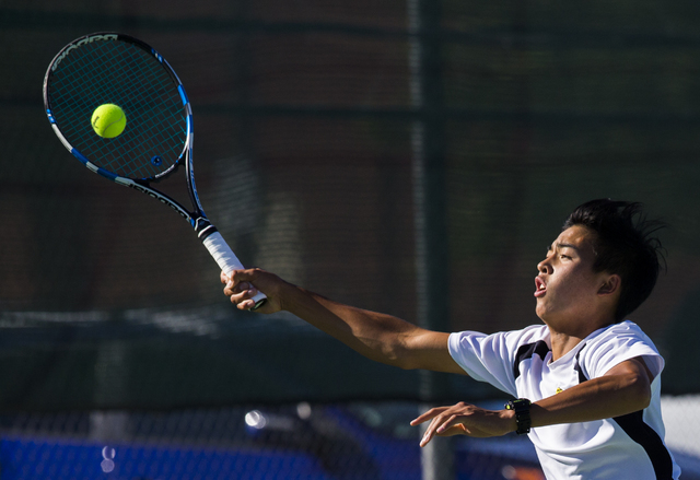 Clark High School’s Michael Pasimio stretches out to return a serve during a home tenn ...