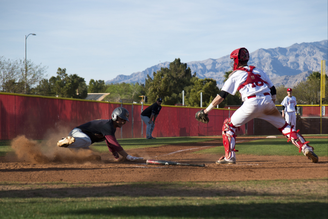 Faith Lutheran’s Josh Harmonay (9) slides into home plate as Arbor View’s Joe Fi ...
