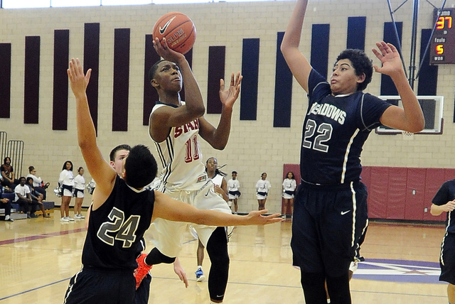 Agassi Prep guard Deishuan Booker (11) is fouled by The Meadows forward Michael Jin (24) whi ...