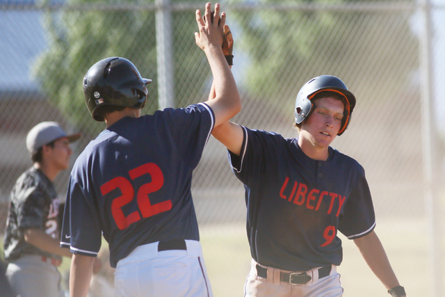Liberty’s Michael Wong left, and Jacob Klein slap hands as Klein scores a run during a ...