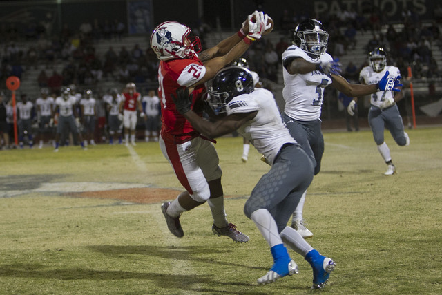 Liberty’s Darion Acohido (21) catches a pass over Desert Pines’ Andrew Gray (8) duri ...